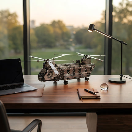 Detailed metallic transport aircraft puzzle displayed as an elegant office desk ornament next to a laptop and desk lamp.