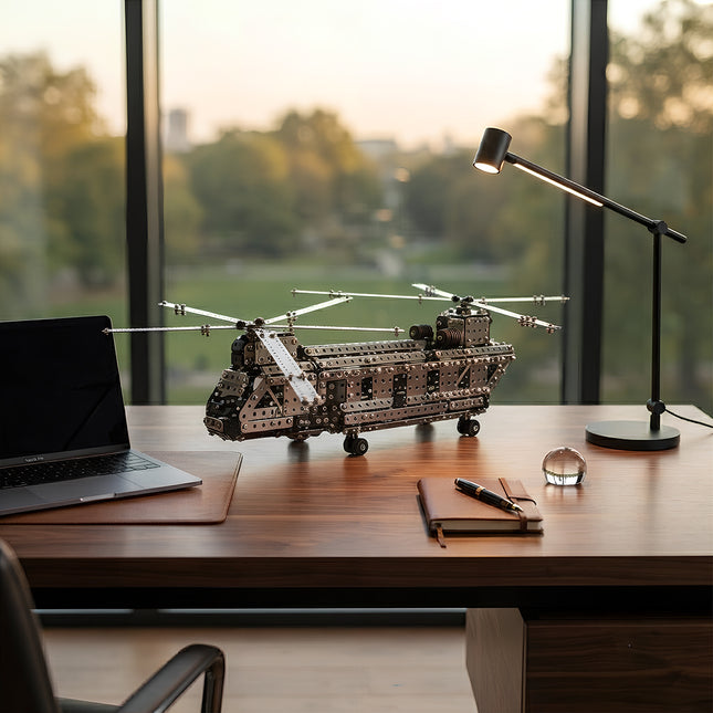 Detailed metallic transport aircraft puzzle displayed as an elegant office desk ornament next to a laptop and desk lamp.