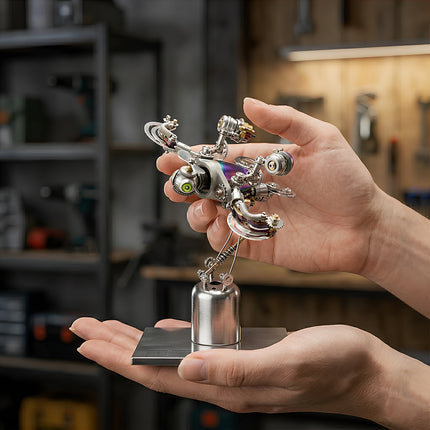 Close-up of hands holding a small, intricate steampunk mech metal model, a unique 3D puzzle featuring gears, springs, and a vibrant iridescent body, standing on a polished metal base.