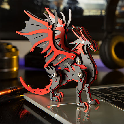 A red and black mechanical dragon steam punk mech metal model standing on a laptop at a geek desk setup.