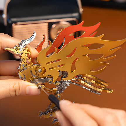 Close-up of a person using a screwdriver to assemble a red and gold Bi Fang bird 3D metal mechanical puzzle.