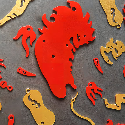 Unassembled red and gold laser-cut metal pieces of the Chinese mythical beast 3D puzzle metal kit arranged on a textured surface.