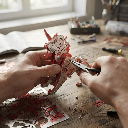 Hands assembling a red and silver Kirin mythical beast metal model, showcasing the intricate steam punk mech details of this 3D puzzle Metal Kit.
