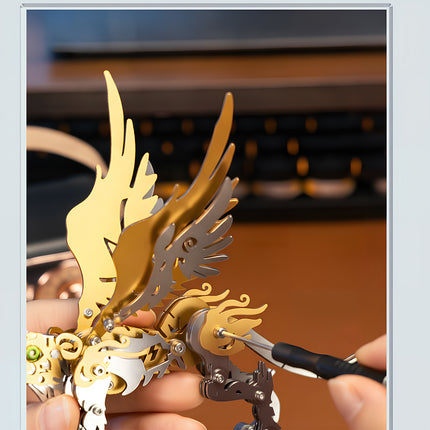 Close-up of assembling the golden wings of a steam punk mech Zhuque Vermilion Bird metal model using a screwdriver.