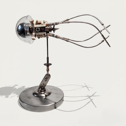 Steampunk DIY 3D metal mechanical squid jellyfish model kit with clear glass-style acrylic dome, intricate metal core, and articulated tentacles on a round base.