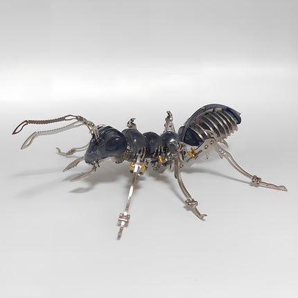 Close-up profile of a steampunk mechanical ant sculpture showing intricate metal legs, antennae, and mandibles.