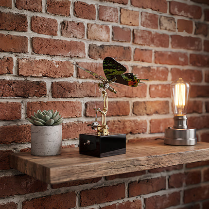 Steampunk mechanical butterfly sculpture on a wooden shelf next to a vintage Edison bulb and succulent plant.