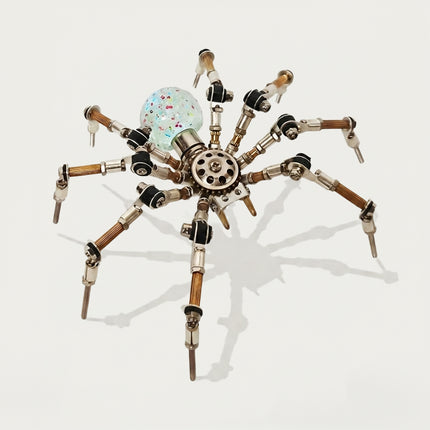A front-angle product shot of the steampunk puzzle spider model against a clean white background, showcasing its rainbow-shifting and speckled translucent spherical abdomen. This creative metal model built from 3D puzzle Metal Kits features multi-jointed metallic legs and an intricate mechanical steampunk mech design.