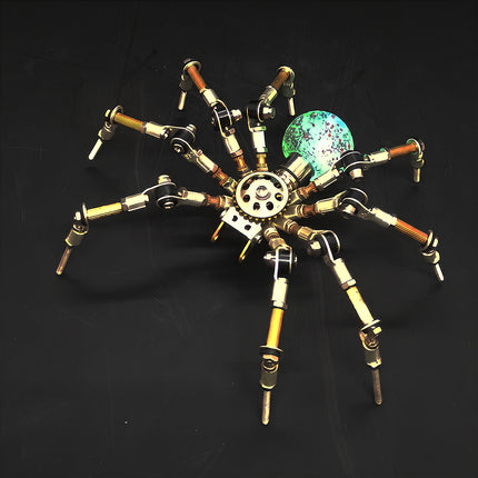 A dramatic night photograph of the steampunk puzzle spider model against a dark background, highlighting a glowing spherical abdomen with vibrant turquoise and speckled details. This exquisite metal model built from precision 3D puzzle Metal Kits showcases intricate multi-jointed legs and an exceptional mechanical steampunk / steam punk mech design.