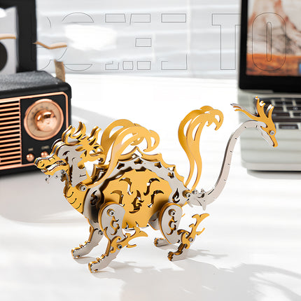 A finished golden and silver Xuanwu Black Tortoise steampunk puzzle metal model displayed on a desk.