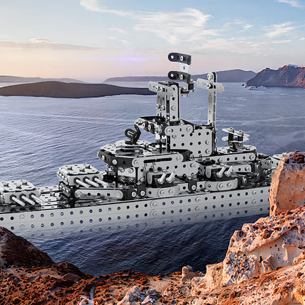 A silver military battleship metal model by TableFunny, realistically displayed set against an ocean and rocky island backdrop. This impressive steam punk mech warship highlights the exquisite collectible value of our 3D puzzle Metal Kits.