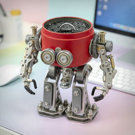 A unique steam punk mech metal model that doubles as a desk organizer, holding items in its red body on an office desk.
